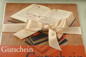 Geschenkgutschein im Buchhandel mit Satinband aufgewertet -